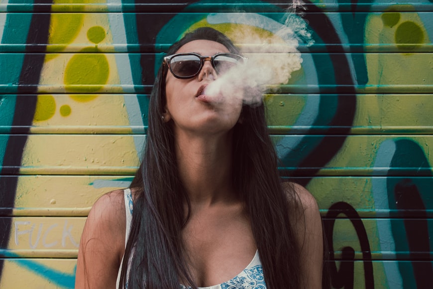 woman wearing sunglasses vaping